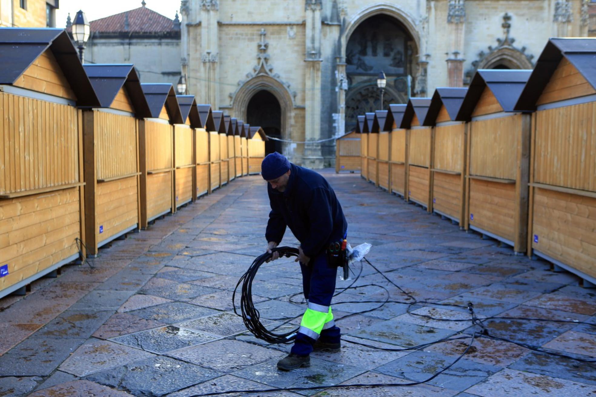 Un hombre retira cableado del mercadillo, que cerró el sábado, de la plaza de la Catedral. 