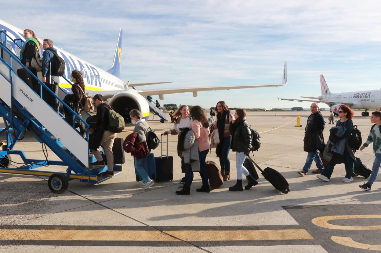 Pasajeros de un vuelo a Dublín suben al avión en el Aeropuerto de Asturias . 