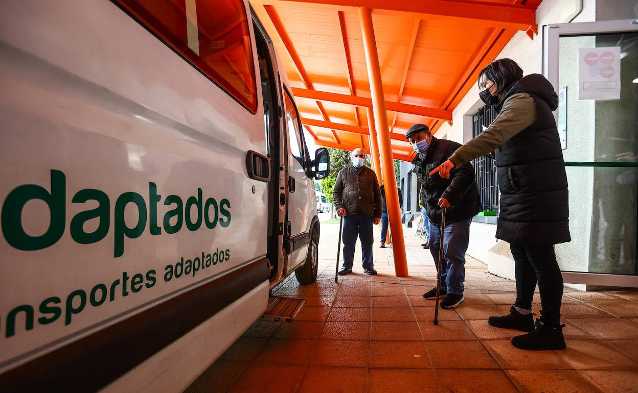 Usuarios del Centro de Día ElNaranco esperan su turno para subir al vehículo que les lleva a sus domicilios. 