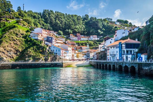 3. Cudillero, Asturias. Sus casas, apiñadas sobre la ladera del monte, parecen 'empujarse' para poder ver el mar. Abajo, el puerto, desde donde se contempla el pueblo 'trepando' montaña arriba. Es una larga calle principal a la que van a dar otras estrechas, casi todas escalonadas. La villa es punto importante del Camino de Santiago costero. El muelle viejo está lleno de bares y chigres, donde se toma sobre todo sidra, sardinas a la plancha, merluza, caldereta, o besugo. Al atardecer llegan las barcas de pesca y se abren pequeños tenderetes, en los bajos de las casas, donde se puede comprar el pescado recién llegado. Muy cerca está la conocida Playa del Silencio, apenas 500 metros de arenal salvaje y aguas de matices esmeraldas en los días soleados, gracias a su sustrato rocoso. Asomarse desde los dos miradores sobre el acantilado que confina la playa es cómo abarcar toda su belleza natural.