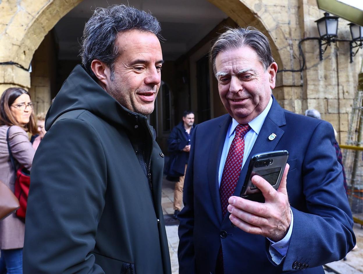 El alcalde, Alfredo Canteli, a la derecha, muestra su teléfono a Nacho Cuesta. 