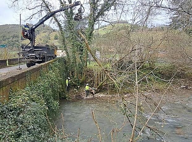 Unos operarios trabajando en el río Cubia. 