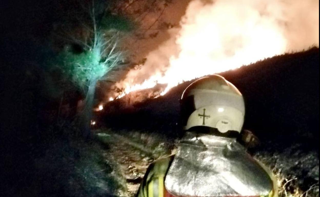 Labores de extinción de un incendio forestal entre las localidades de Alvaré y La Caridad, en Grado esta noche. horas.