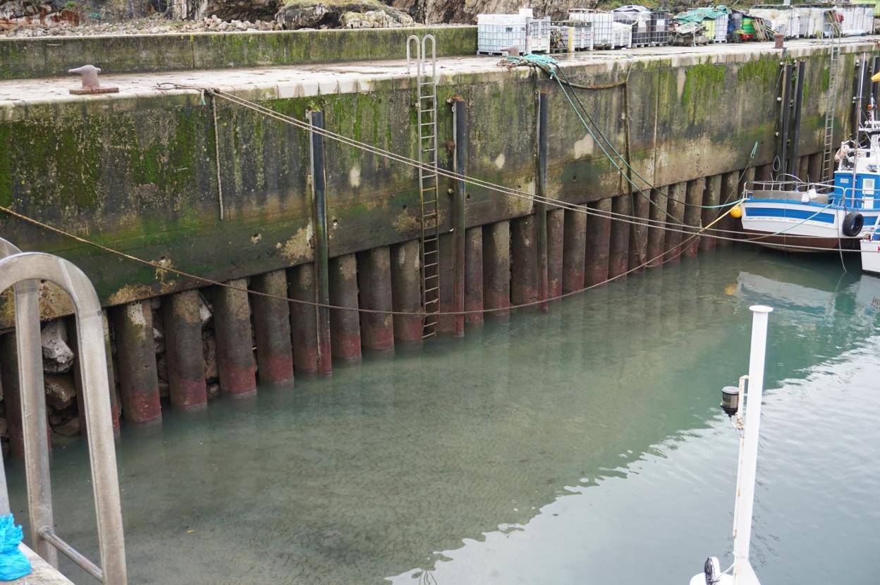 La presencia de sedimentos en la zona pesquera del puerto de Llanes complica el amarre de los barcos. 