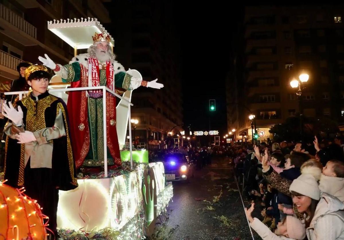 Melchor, en la pasada cabalgata de 2023, saluda a los niños de Gijón.