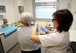 Una enfermera pone una vacuna contra la gripe a una paciente de Oviedo.