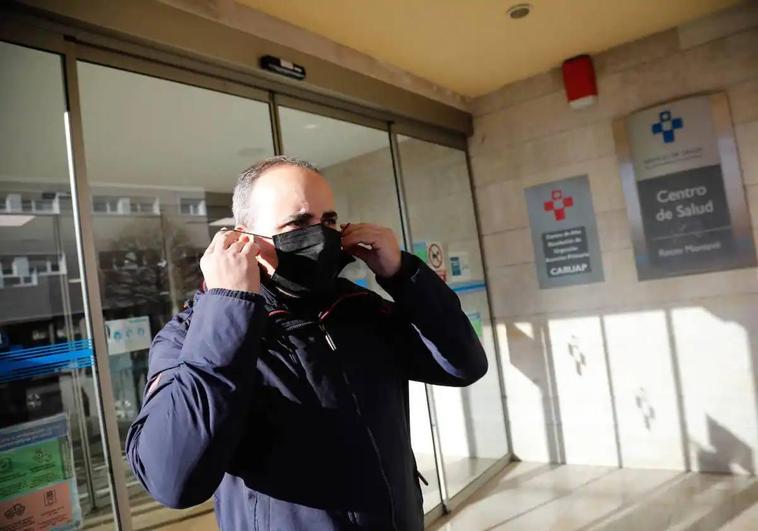 Un paciente se retira la mascarilla al salir del centro de salud de Montevil, en Gijón.