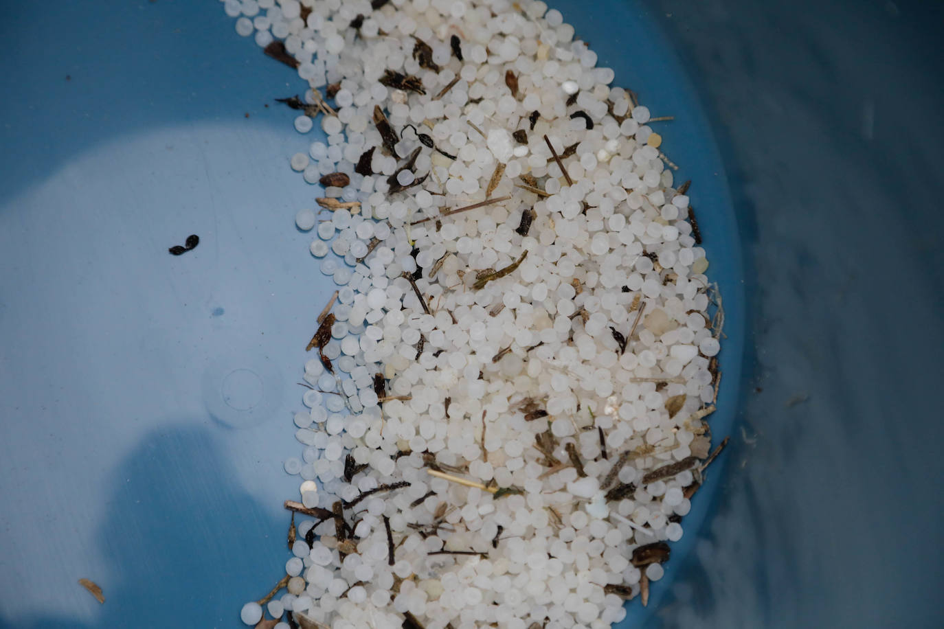 Operarios retiran los pellets o bolitas para fabricar plástico que aparecen en las playas de Asturias, tras la caída de un contenedor de un barco el pasado diciembre, esta mañana en la playa asturiana del Aguilar.