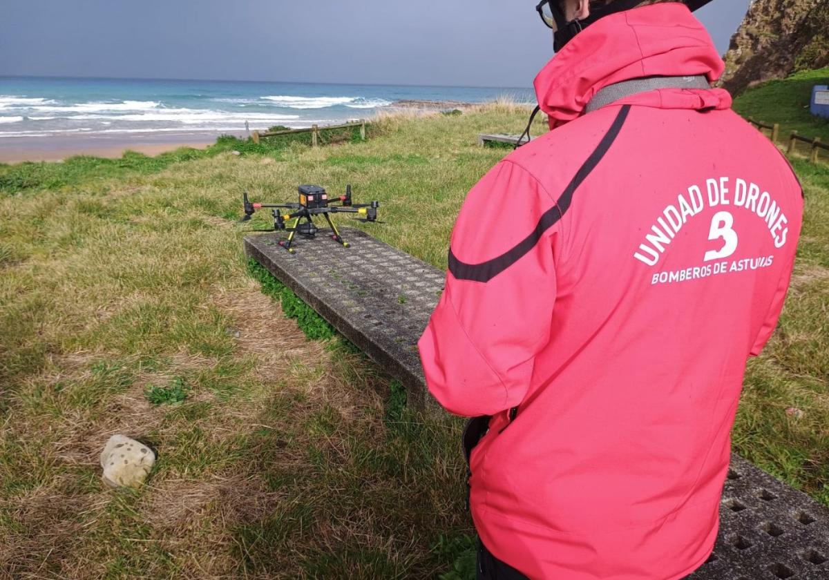 Un piloto de drones de Bomberos de Asturias se dispone a hacer volar un dron sobre el playón de Vega.