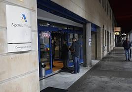 Dos personas esperan para entrar en la delegación de Gijón de la Agencia Tributaria.
