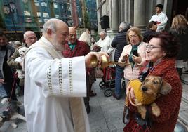 Francisco Javier Suárez bendice a 'Watson', en el cuello de Rosa Pereiro, durante el acto con motivo de la festividad de San Antón a las puertas de la basílica.