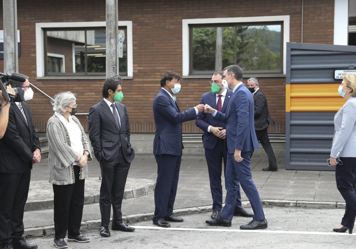 El presidente del Gobierno y el de Arcelor chocan los puños en el acto de presentación del plan verde, en la factoría de Gijón en 2021.