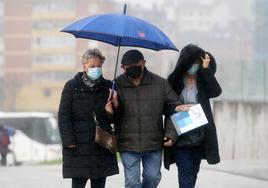 Tres personas se protegen de la lluvia, este jueves, en Oviedo.