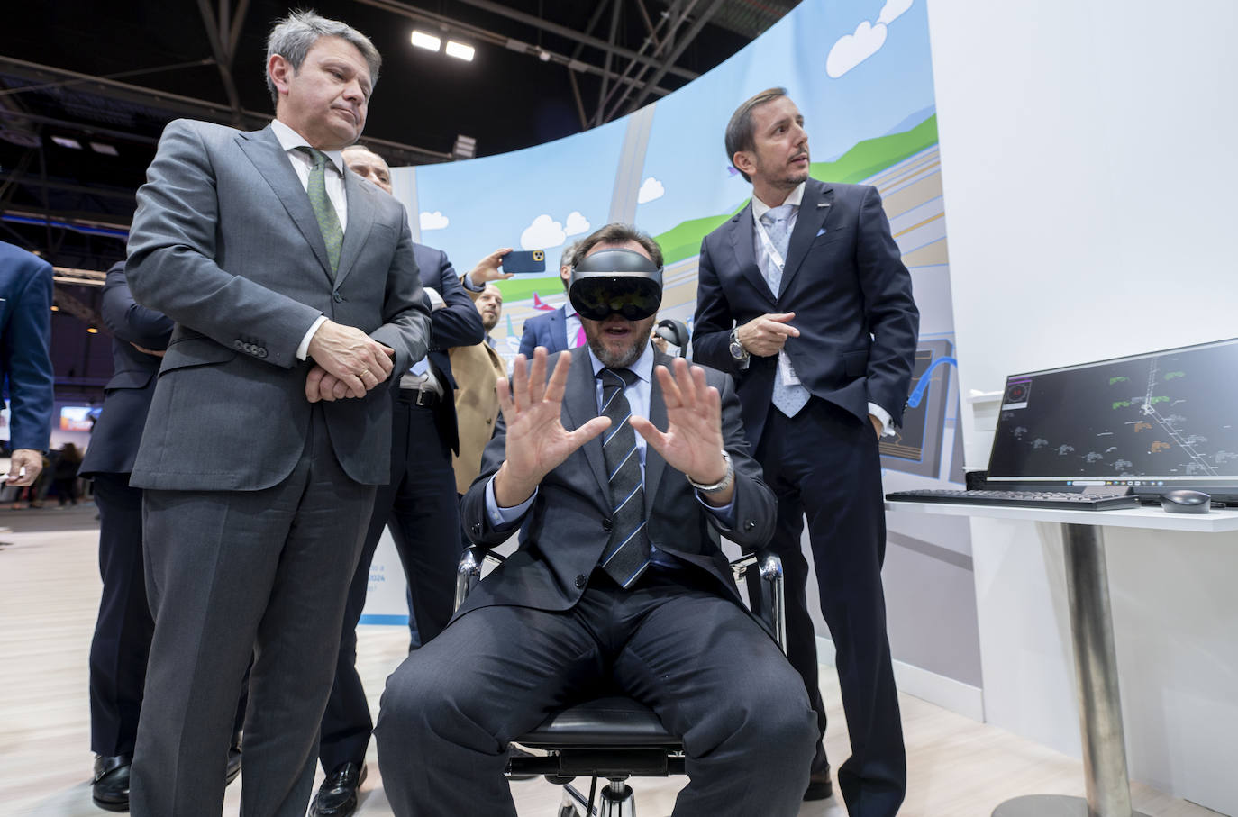 El ministro Óscar Puente, con unas gafas de realidad virtual, entre el secretario de Estado, José Antonio Santano.