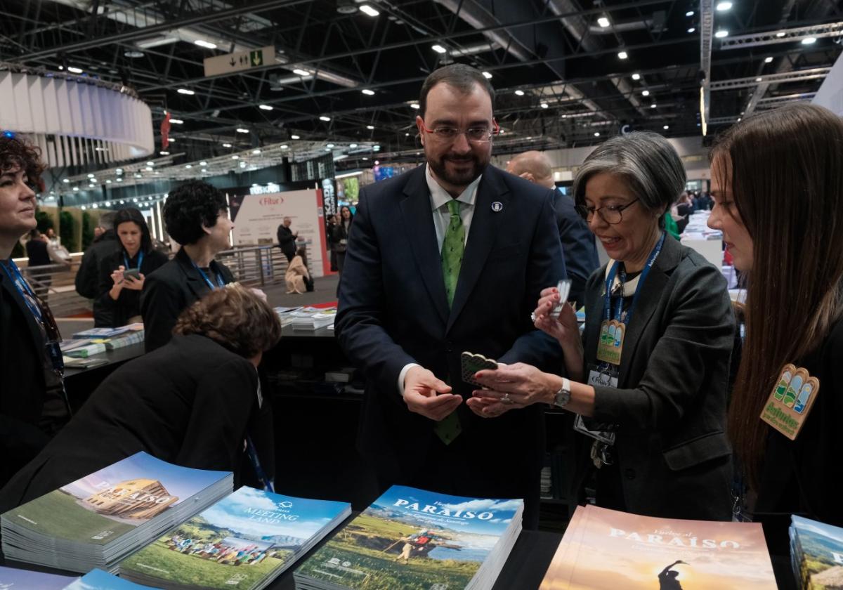 El presidente del Principado observa el material informativo y merchandising del estand de Asturias en Fitur.