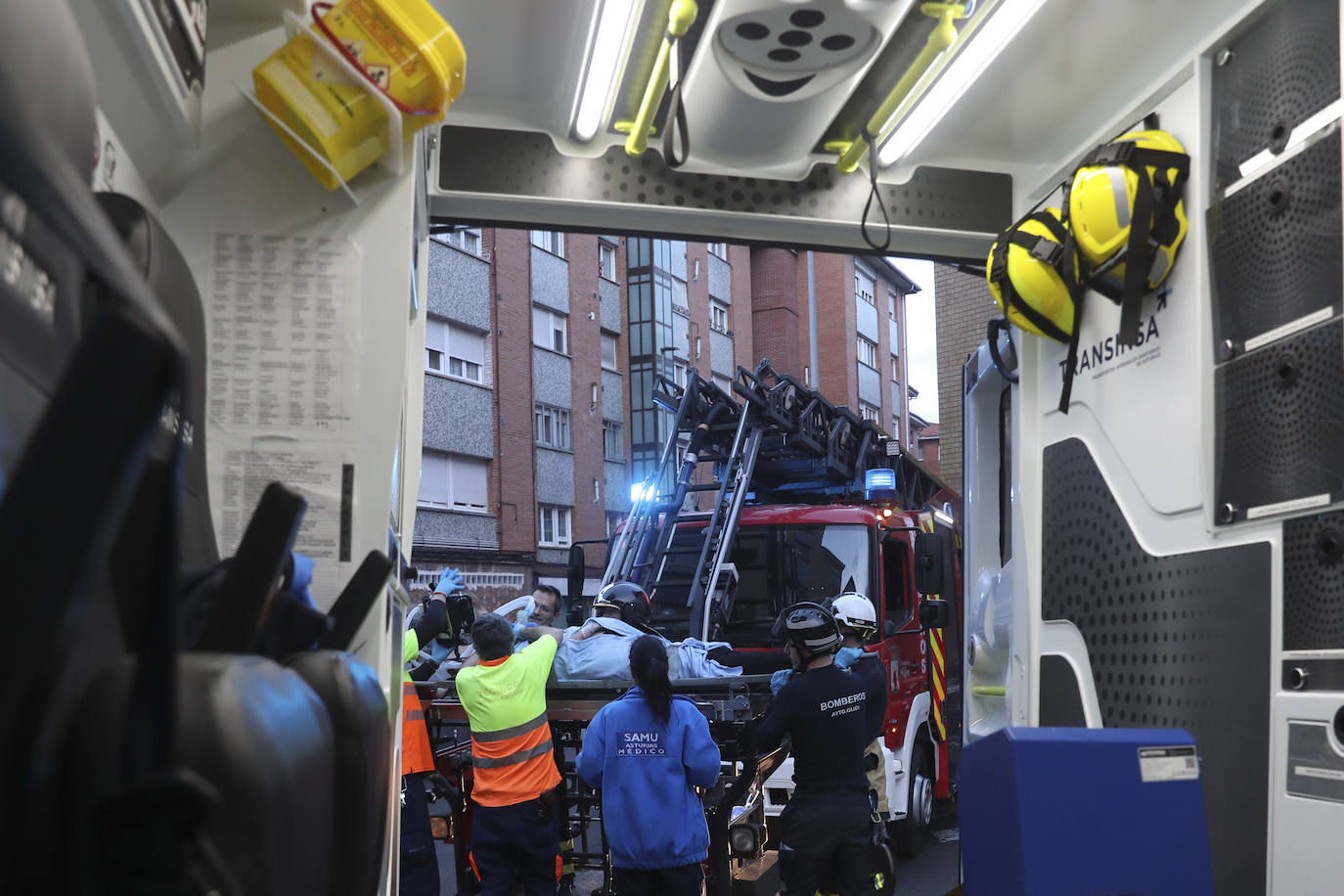 Maniobra de los bomberos de Gijón para sacar a una mujer inconsciente por la ventana