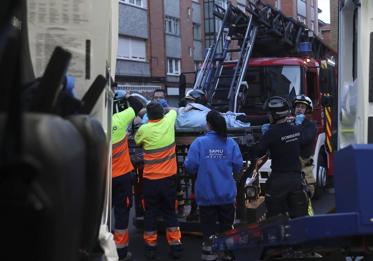 Maniobra de los bomberos de Gijón para sacar a una mujer inconsciente por la ventana