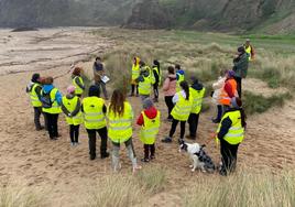 Los voluntarios reciben instrucciones antes de empezar a arrancar plantas invasoras, ayer, en la playa gozoniega de Xagó.