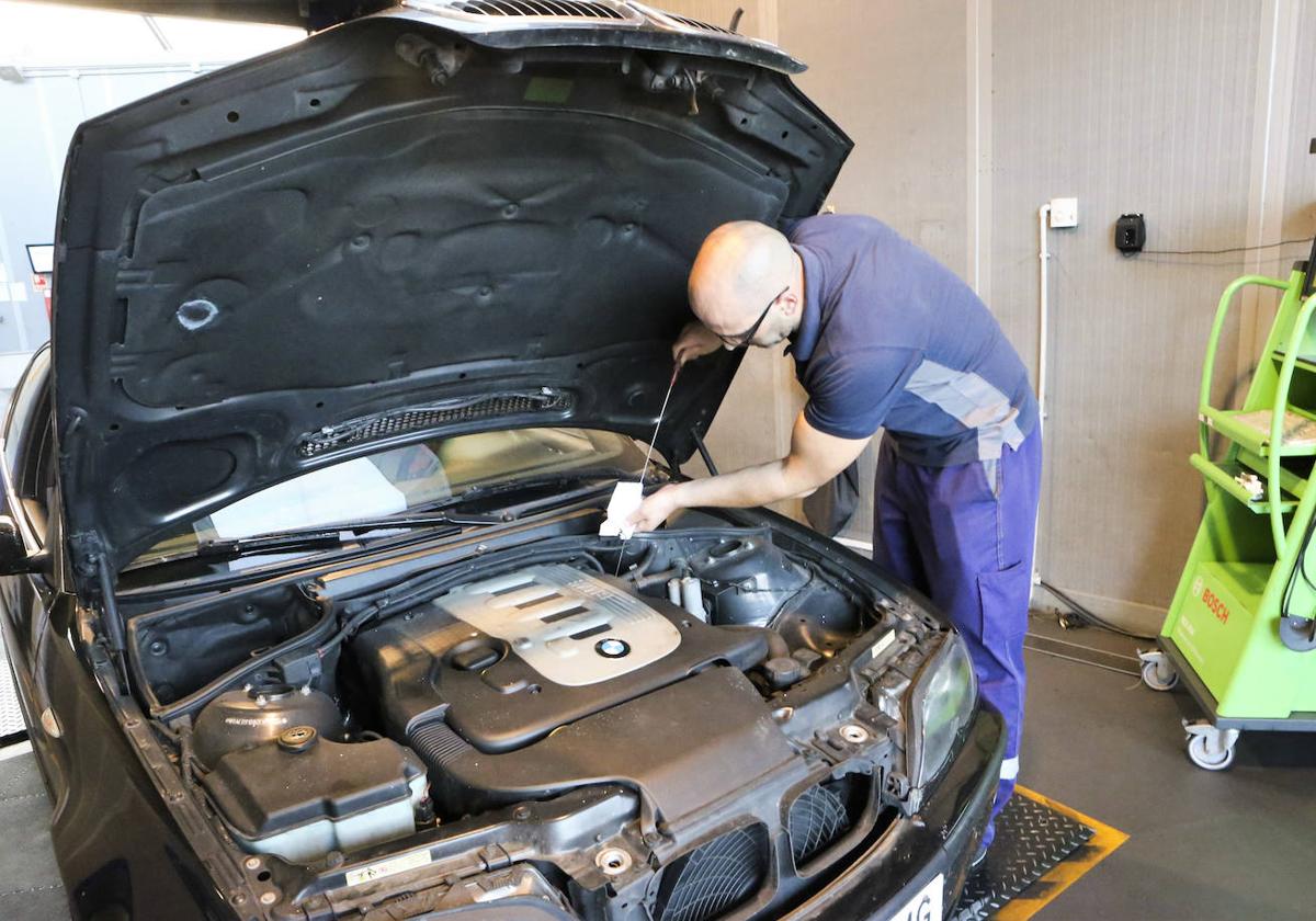 Un hombre inspecciona un coche en la ITV de Pruvia.