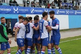 Davo Fernández y Natalio, los goleadores blanquiazules de ayer, se abrazan rodeados por parte de sus compañeros.