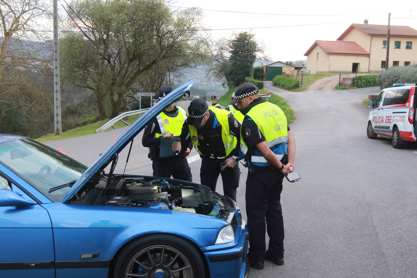 Tres agentes inspeccionan un vehículo.