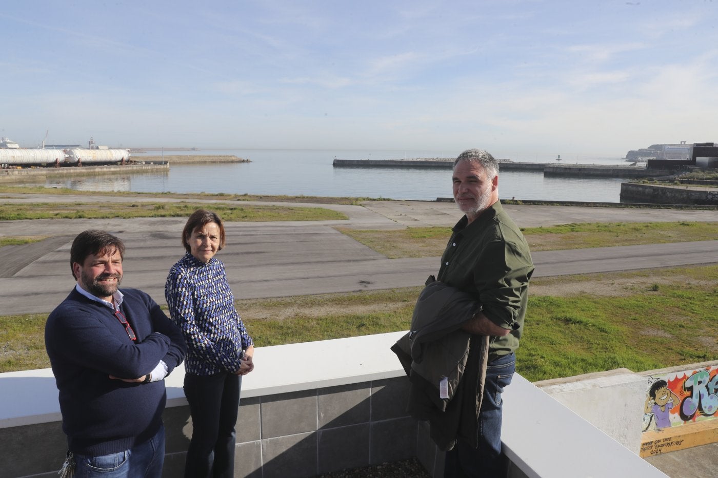 Rafael Piñera, Carmen Moriyón y José Luis Casaprima, en la terraza del Hogar de San José, con los terrenos de Naval Gijón al fondo.