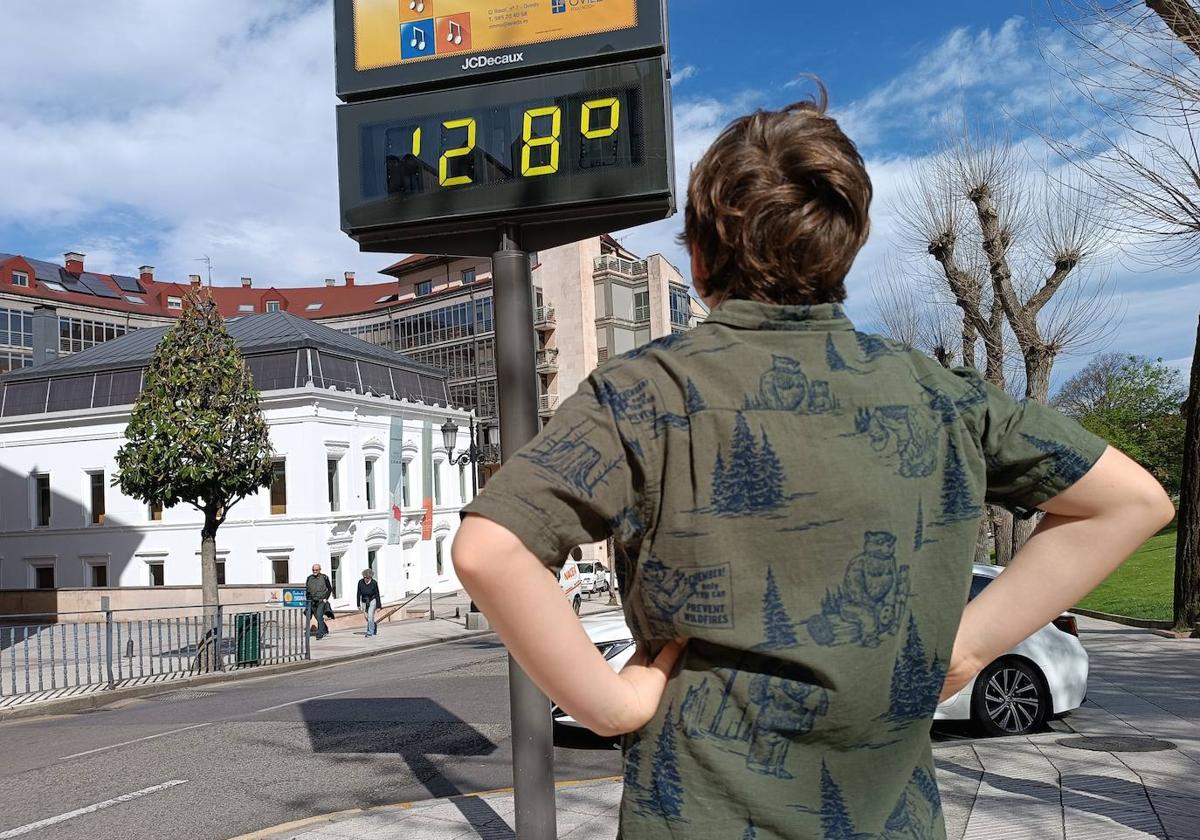 Un ovetense observa el termómetro, que marca 28 grados.