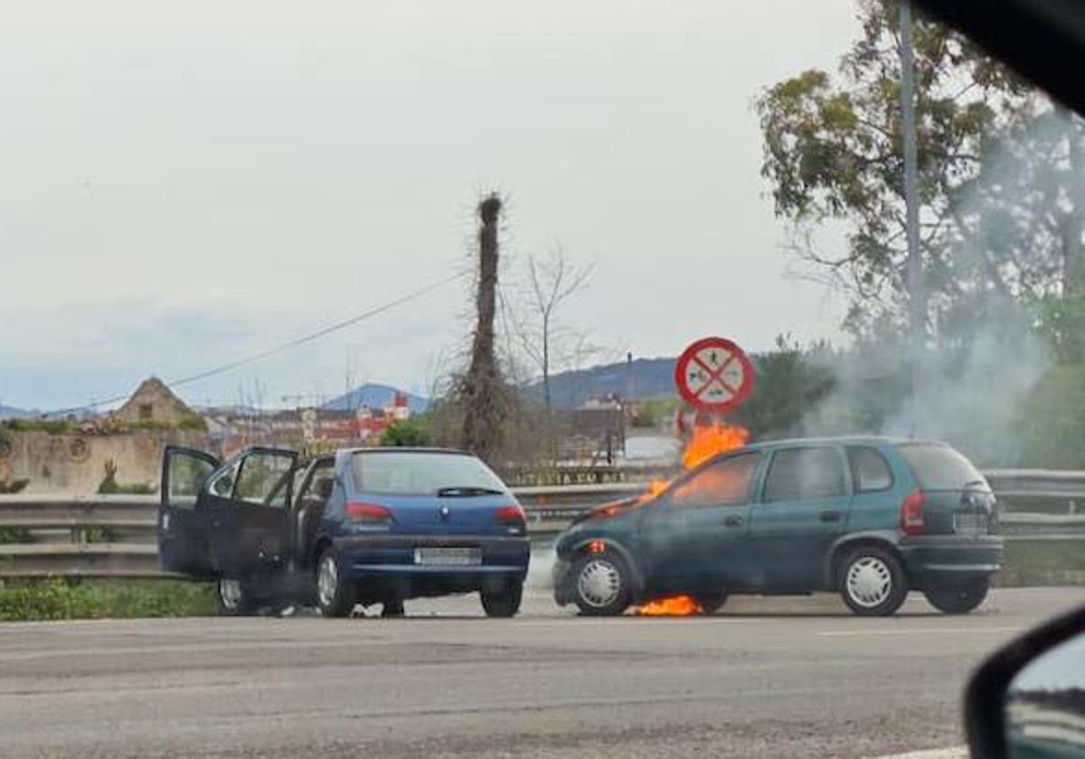 Los dos coches implicados en el accidente, uno de ellos envuelto en llamas.