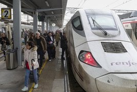 Pasajeros en uno de los primeros trenes comerciales que recorrió la variante de Pajares, en la estación de Gijón.