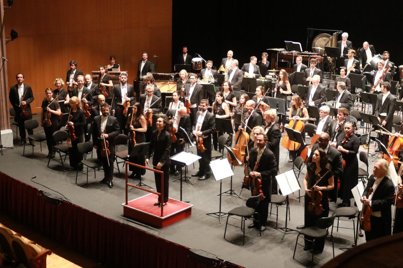 Los músicos, en pie, se dirigen al público asistente al Teatro Jovellanos.