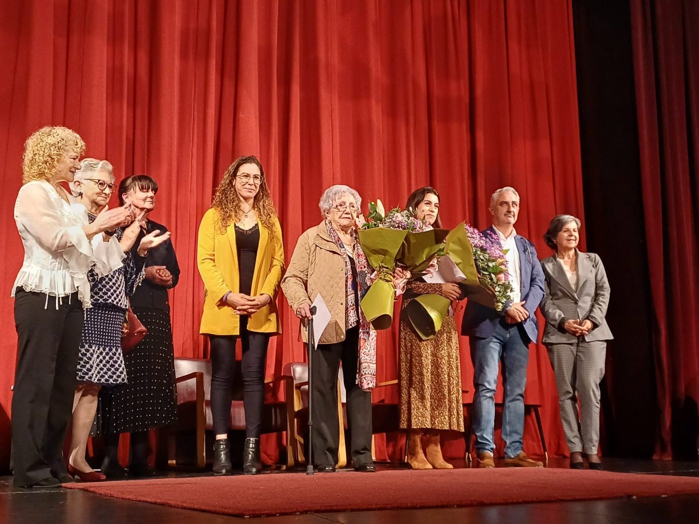 Generosa'l Llano y Gisele Fernandes, con los ramos de flores, durante el homenaje.