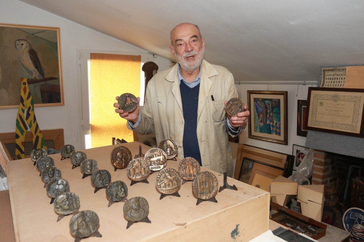 Juan Zaratiegui, en su taller, muestra la colección de medallas que ha donado.