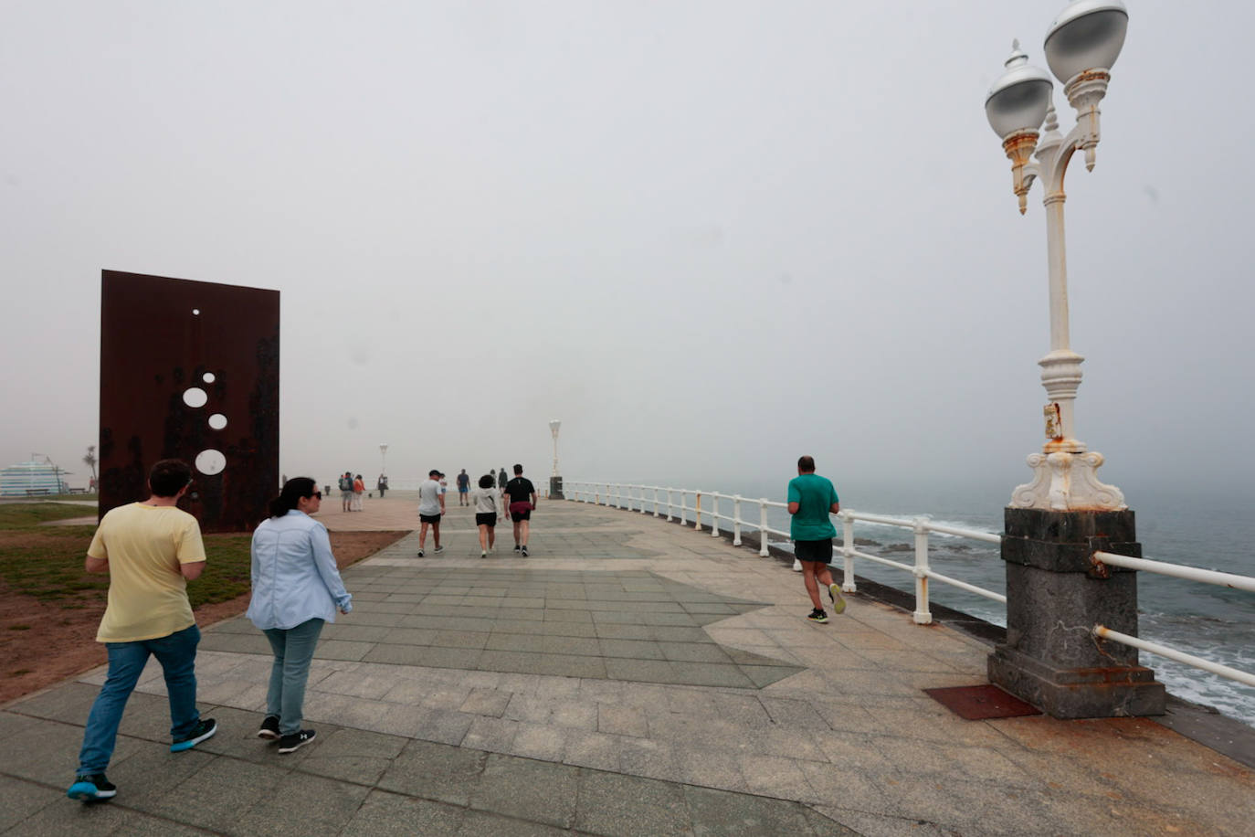 Gijón pasa de un día de sol y playa a una mañana siguiente de niebla