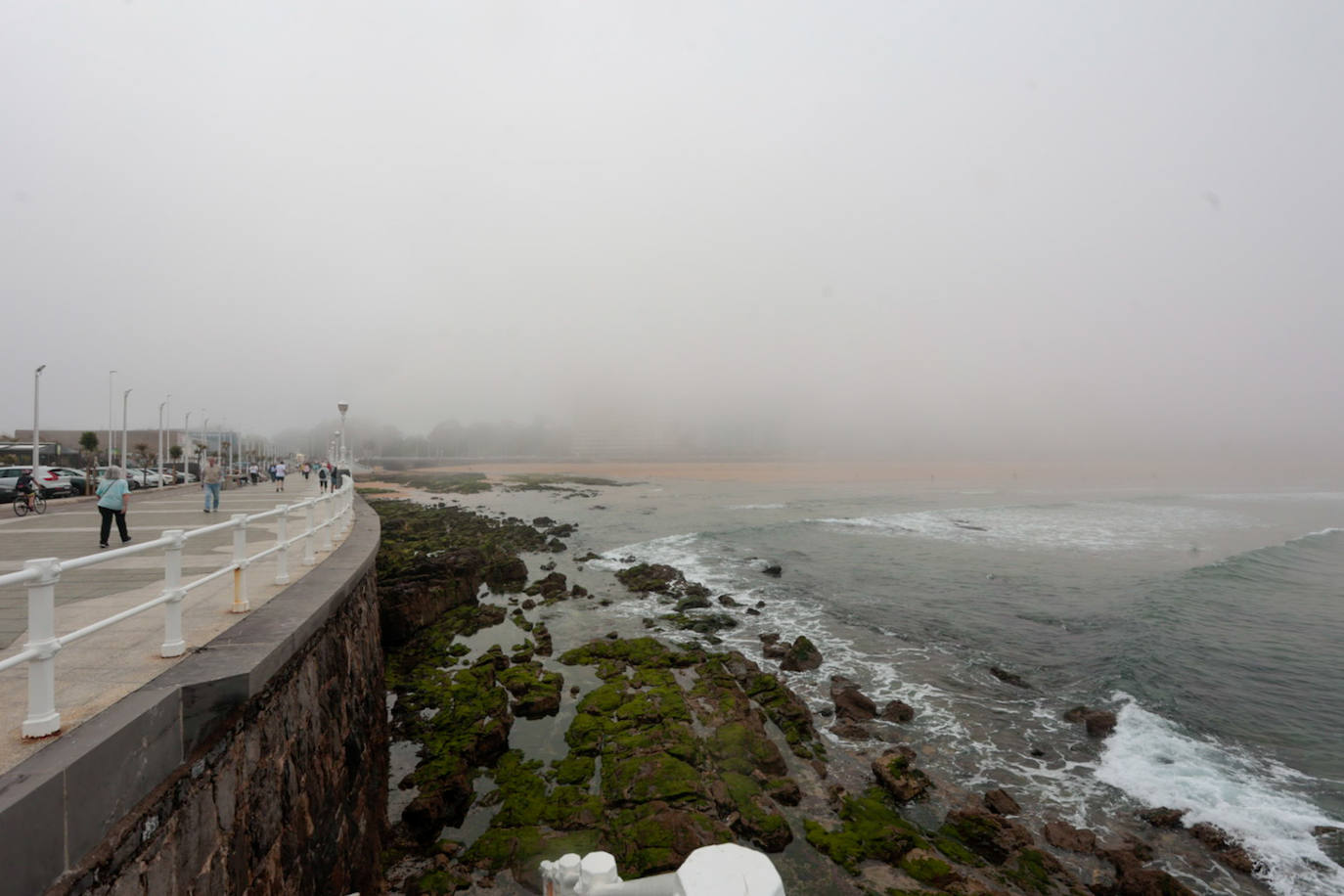 Gijón pasa de un día de sol y playa a una mañana siguiente de niebla