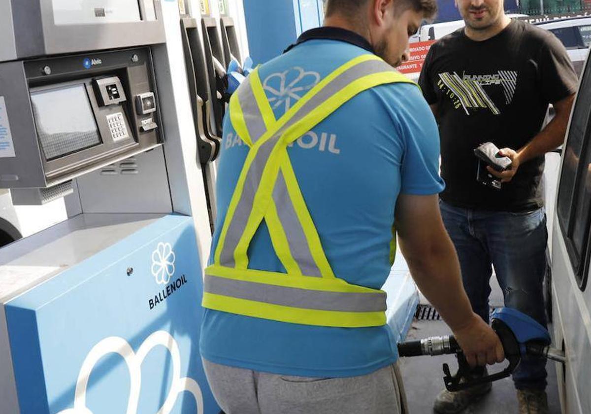 Un trabajador de una estación de servicio de Gijón reposta el vehículo de un cliente.