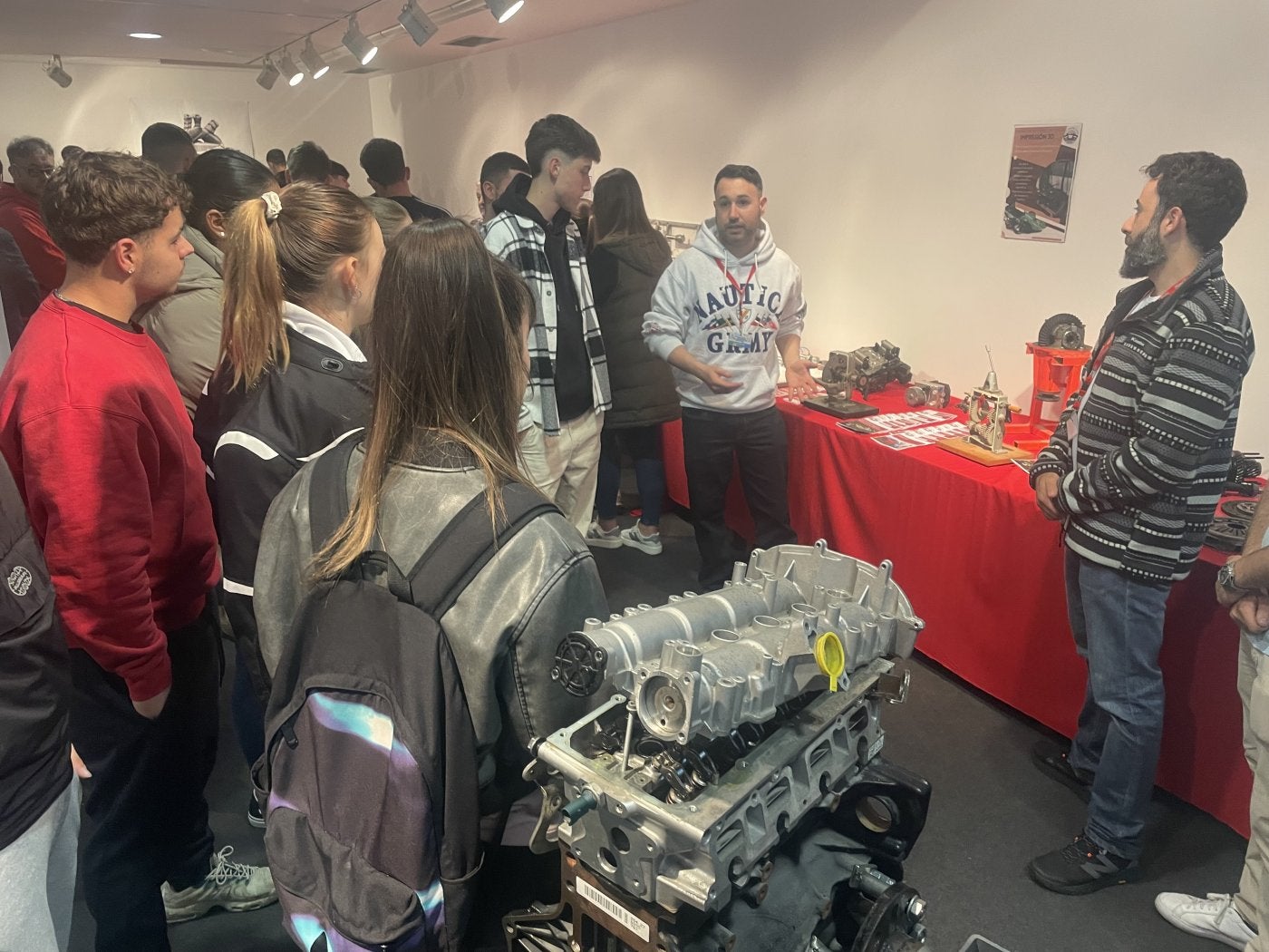 Alumnos del IES Valle de Aller, en Moreda, atienden a las explicaciones en uno de los estands de la feria de la FP de Mieres.