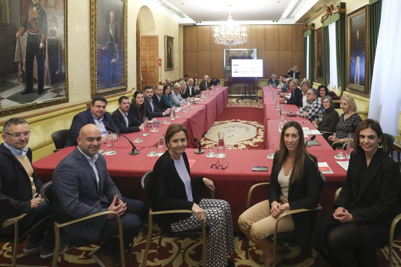 Gilberto Villoria, Jesús Martínez Salvador, Carmen Moriyón, Ángela Pumariega y María Mitre, en la mesa presidencial del Consejo Social de Gijón. En el resto de la mesa se disponen los representantes del Principado, partidos, asociaciones empresariales y financieras, sindicatos, consejos sectoriales y entidades socioeconómicas.
