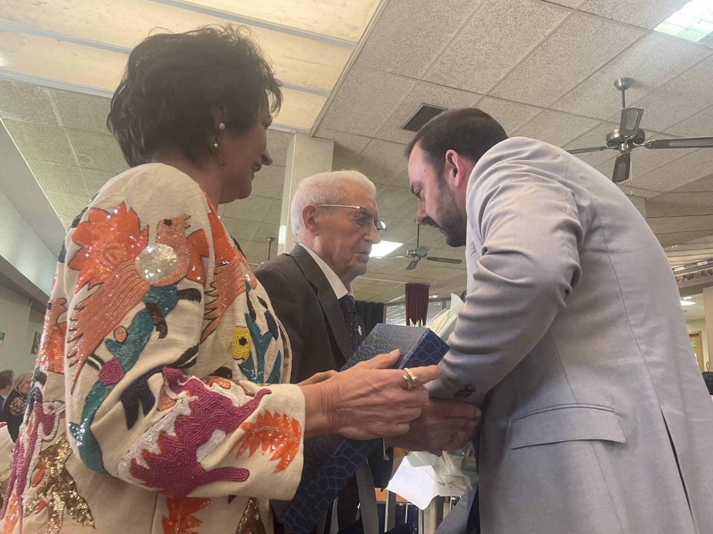 El regidor mierense invitando a Julio González, junto a su hija, a ir al Ayuntamiento a hablar de obras.