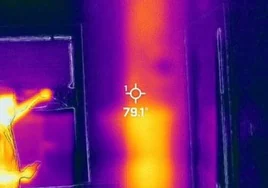 Una imagen con cámara térmica en la que se ve que hay algo que emite calor tras la pared.