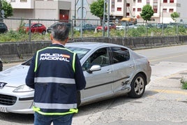 Uno de los agentes de la Policía Nacional que lleva la investigación, el lunes, recogiendo pruebas junto al coche de la víctima.