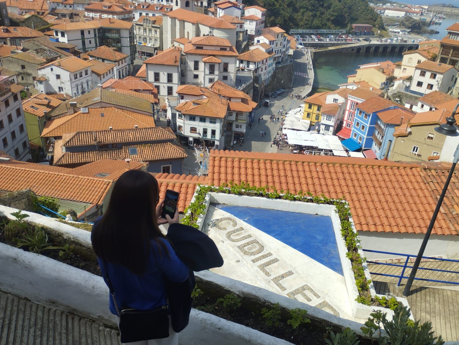 Una turista fotografía las vistas de Cudillero.