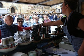 Clientes en uno de los puestos de venta de quesos Cabrales de la plaza de la Catedral.