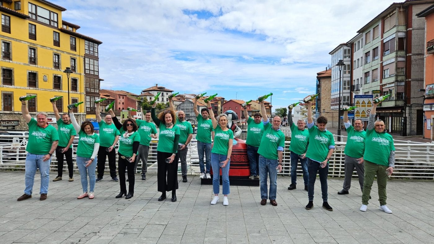 Los hosteleros llaniscos simbolizan su apoyo a la sidra de DOP escanciando en el puente del puerto.