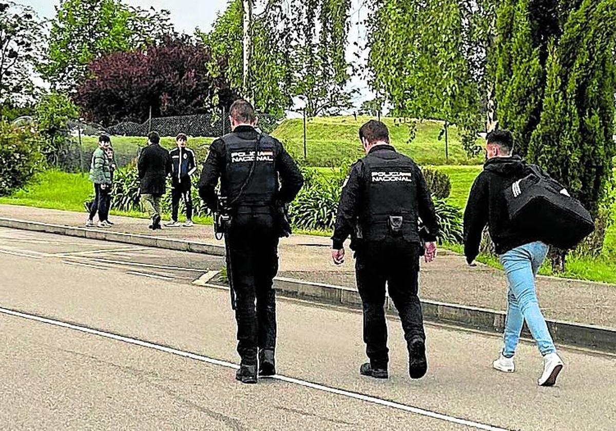 El colegiado abandona las instalaciones escoltado por dos agentes de la Policía Nacional.