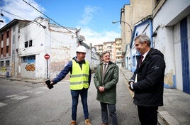 El concejal de Seguridad Ciudadana, José Ramón Prado, en el centro, con responsables de la constructora Refovem y del Ayuntamiento, ante la nave incendiada, sobre la que se eleva una excavadora.