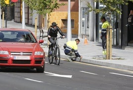 Dos obreros marcan una de las baldosas sueltas en la avenida Pablo Iglesias donde se están subsanando los desperfectos.