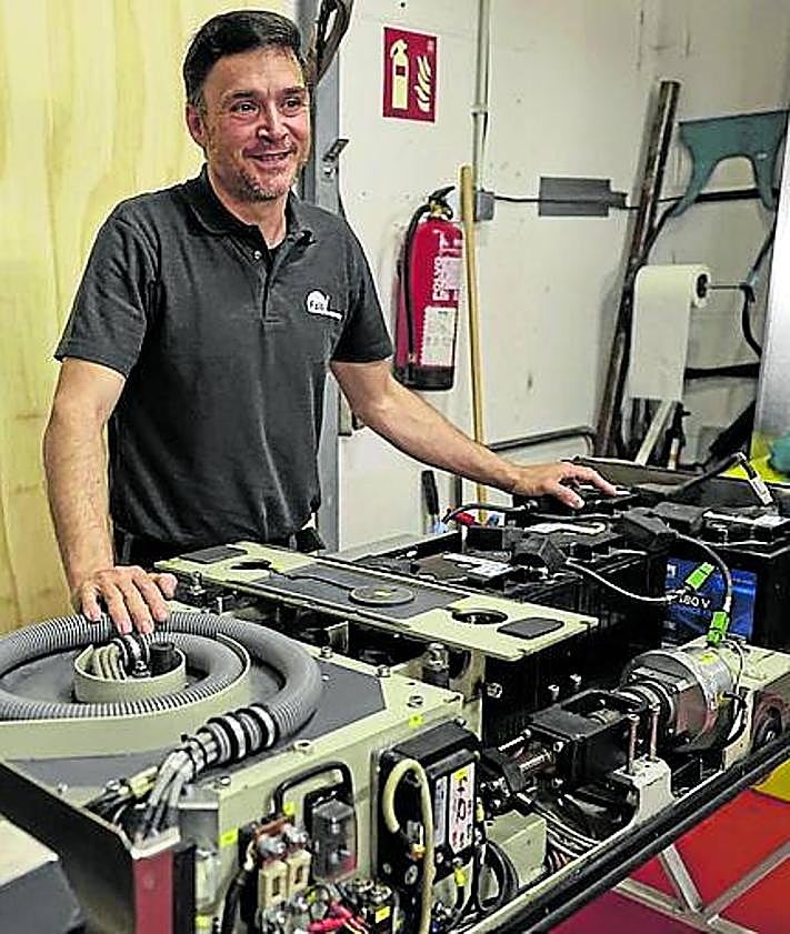 Imagen secundaria 2 - La cocina. Una instalación de 1.500 metros cuadrados en la que trabajan 160 personas. En la imagen, el turno de comida sirve las bandejas en cadena, siguiendo las indicaciones dietéticas pautadas para cada paciente. Los robots. Son 14. Éste, en concreto, espera para acoplarse bajo un carro de comida, ante la mirada de Alfonso Álvarez. Taller. Todos los días se desmonta un robot para hacerle mantenimiento. Como un coche de F1. Al frente del taller está Antolín Eloy Llamas