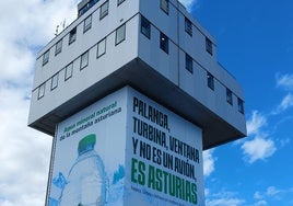 El anuncio de una empresa de agua cubre todo el fuste de la torre asturiana.