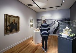 Un visitante contempla la exposición. A la izquierda, un retrato de Del Busto firmado por Piñole.