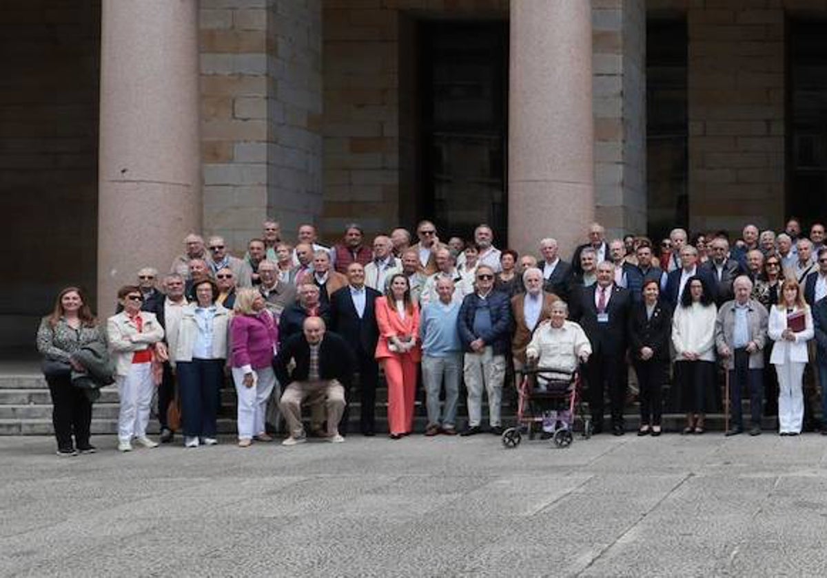 Antiguos alumnos posan con la alcaldesa y la consejera de Cultura en el patio de La Laboral, tras anunciar la presentación a patrimonio de la Unesco.